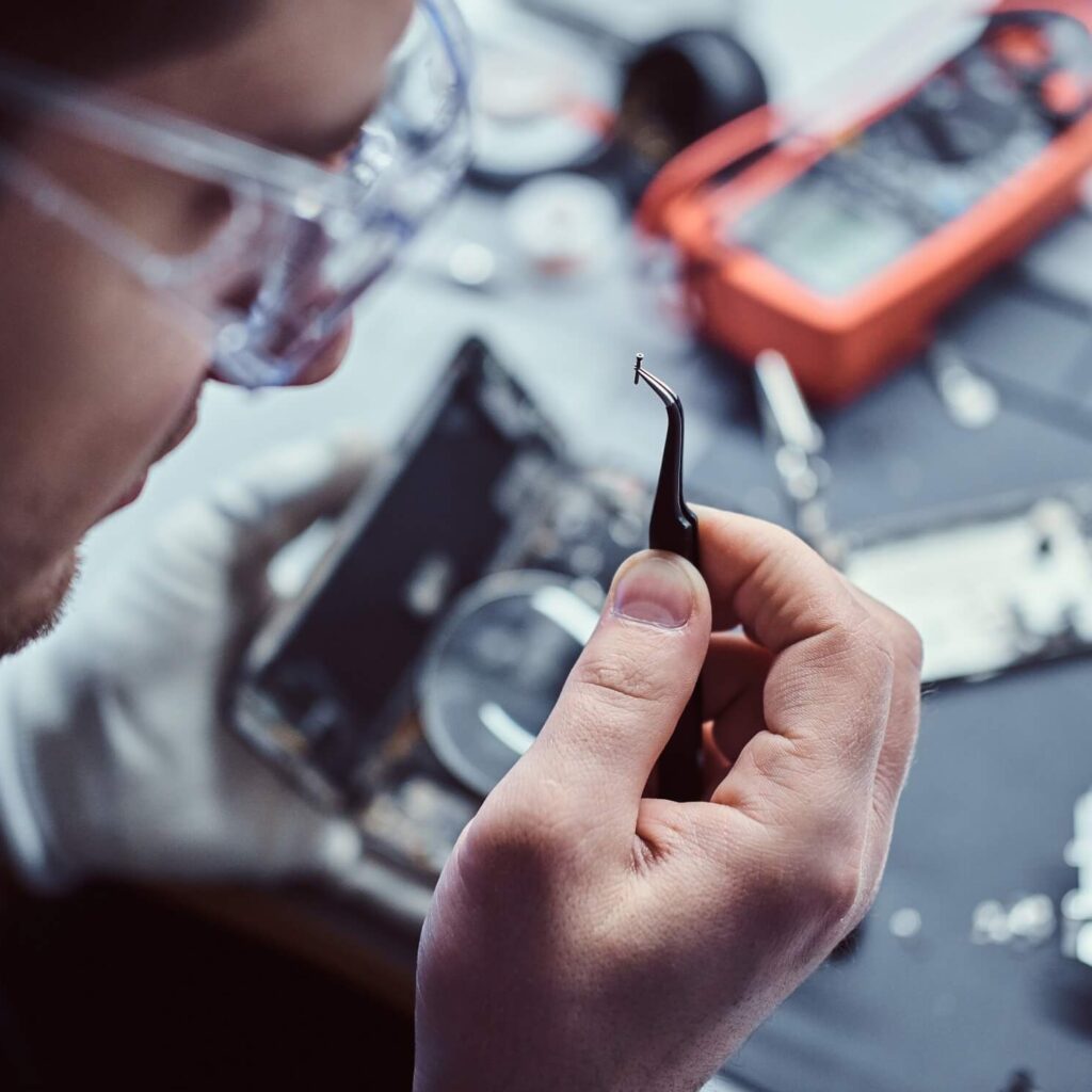 A technician nooling at a phone component close up